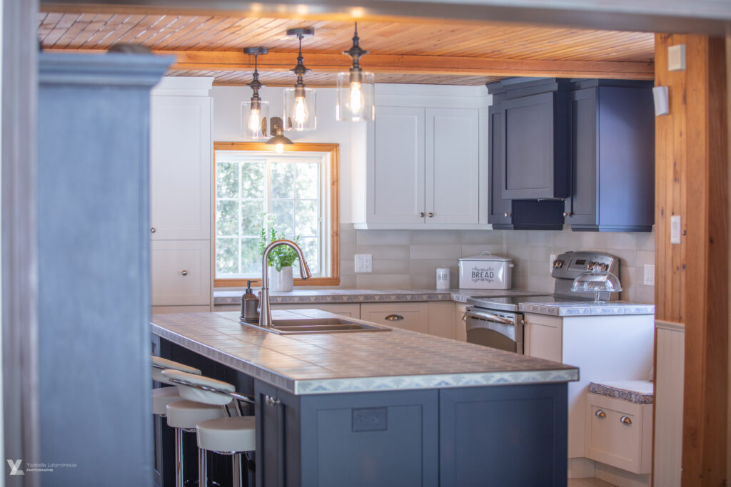 Rénovation de cuisine dans une maison ancestrale de Lanaudière avec armoires blanches, accent bleu et comptoir en tuiles à motifs.