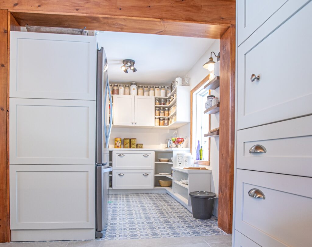 Garde-manger ouvert sur mesure avec rangement abondant, étagères ouvertes et plancher de céramique à motifs dans une maison ancestrale.